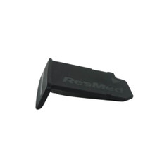The SD card door is black with a short rectangular piece attached at the side to a longer flat piece. The Resmed logo is on the longer piece and on the shorter piece there is a slot for the SD card.